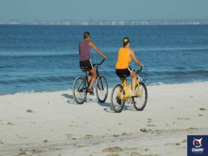 Mujeres montando en bicicleta por la playa 